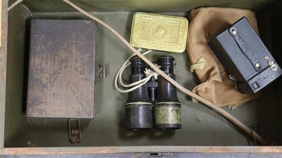 A military tin containing field binoculars and other militaria